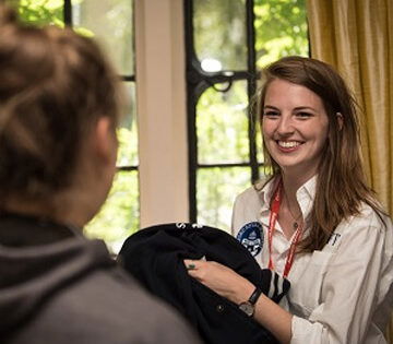 Campus staff member greeting a student on arrivals day